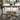 Dining room with a cowhide rug on the floor, table, chairs, and decor.