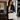 Woman in navy suit carrying cream Saffiano laptop bag in office