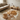 Brown cowhide rug on a wooden floor with a beige sofa and wooden coffee table in the background.